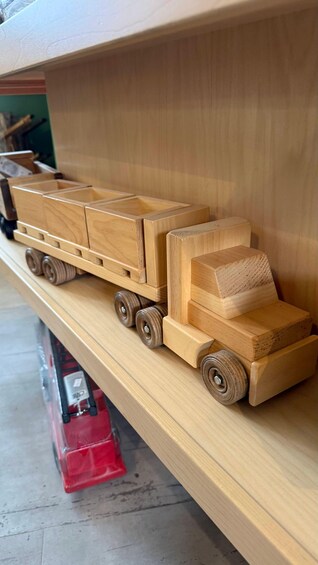 A wooden toy truck on a shelf. 2