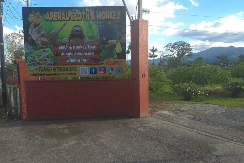 A signboard for a sloth and monkey tour, featuring sloths and monkeys, with contact information and a QR code. 2