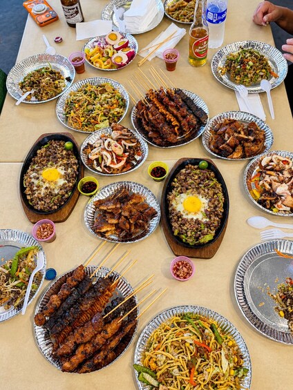A table with various dishes including fried rice, skewers, and stir-fried vegetables. 4
