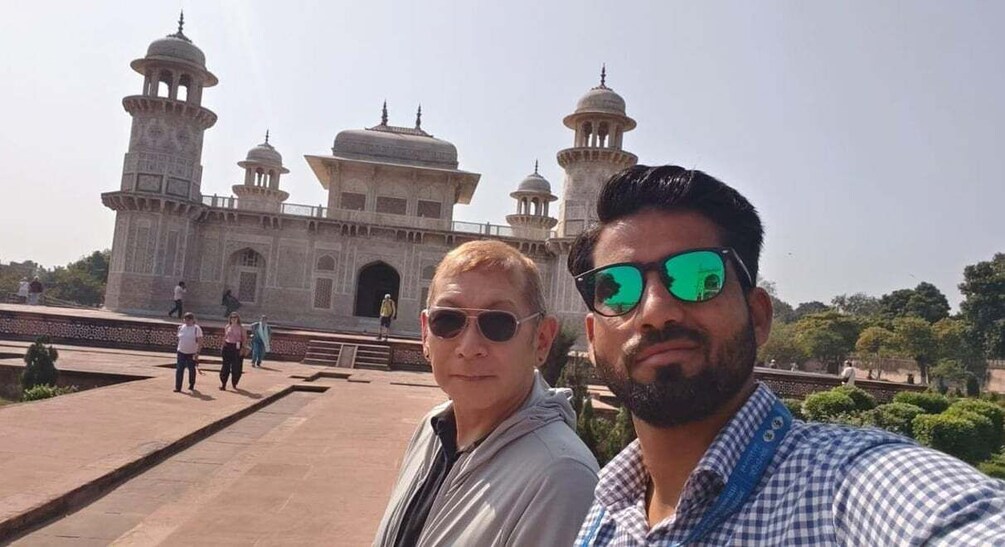 A historic building with domes and minarets, a paved walkway, and people in the background. 5