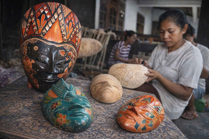 A person crafting a decorative mask with intricate patterns. 1