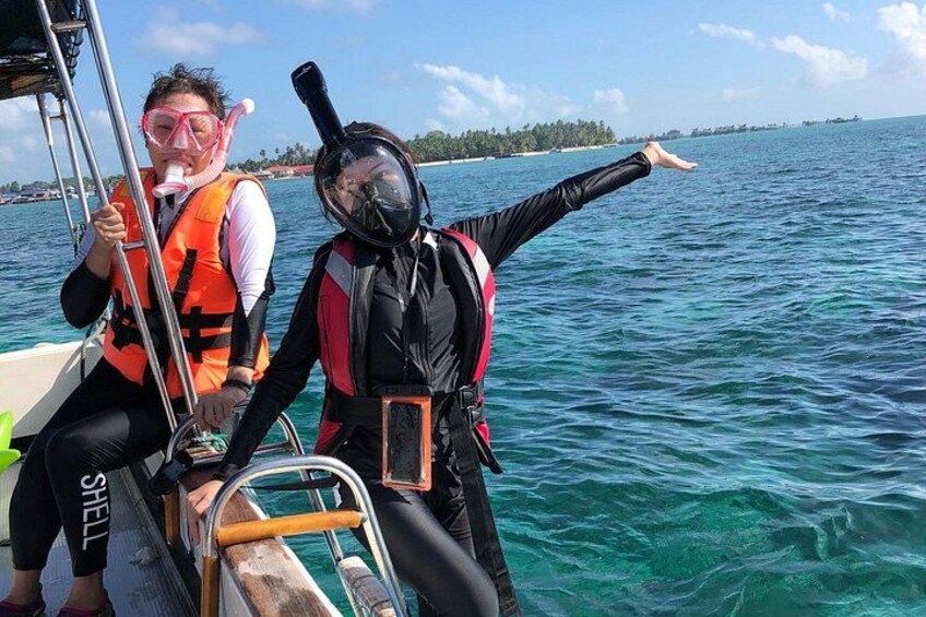Dos personas en un bote con equipo de buceo, señalando hacia el horizonte. 2