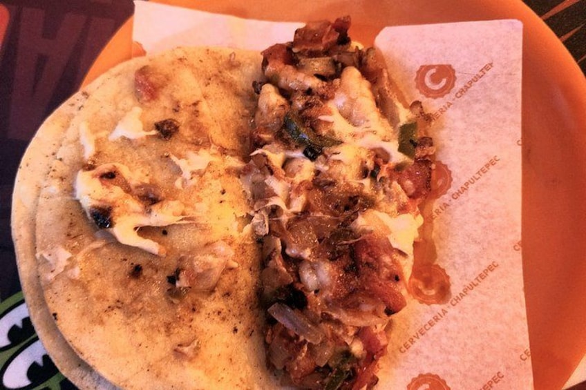 A flatbread with toppings, possibly a type of flatbread or wrap, on a paper liner. 2