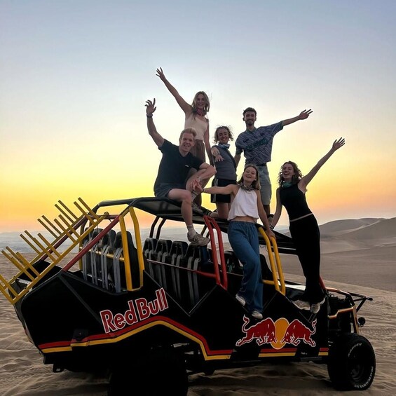 A group of people on a Red Bull dune buggy in a desert landscape. 2