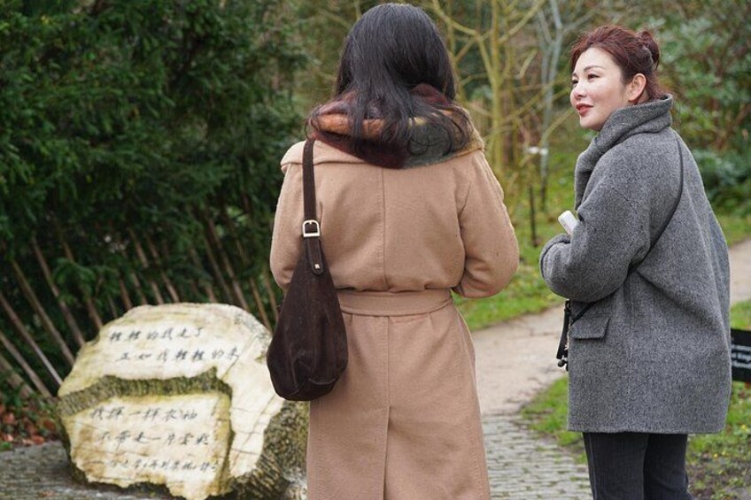 Dos personas de pie en un sendero junto a una gran piedra con inscripciones. 5