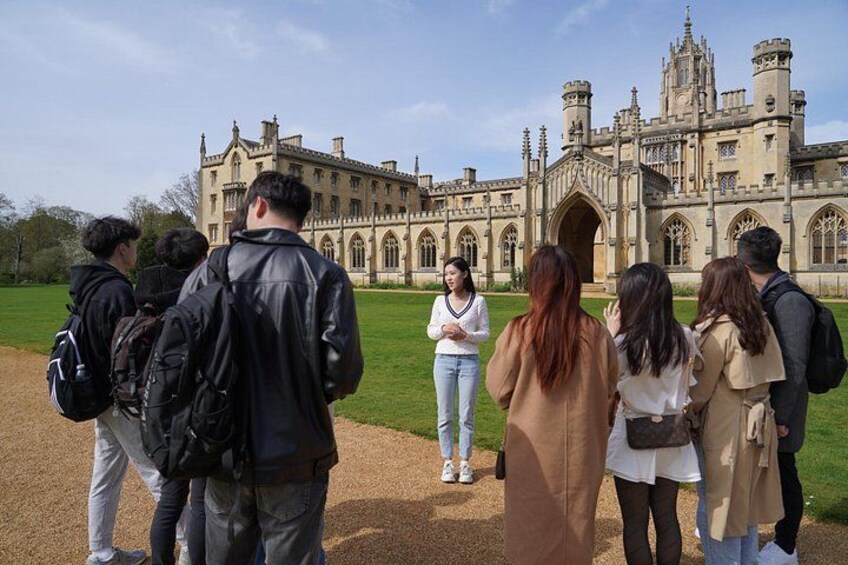 A group of people standing in front of a large, historic building with a castle-like architecture. 3