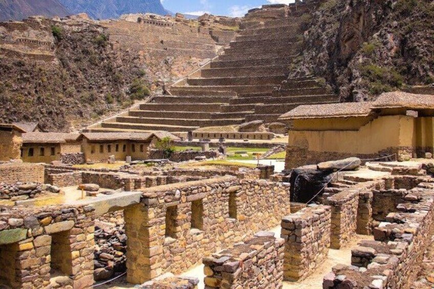 Antiguas estructuras de piedra, escalones en terrazas y un telón de fondo montañoso. 2