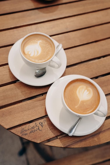 Two cups of coffee with latte art on a wooden table. 4
