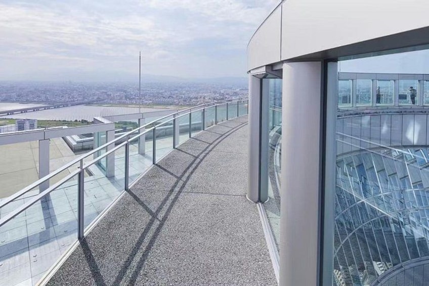A glass-walled observation deck with a cityscape view. 3