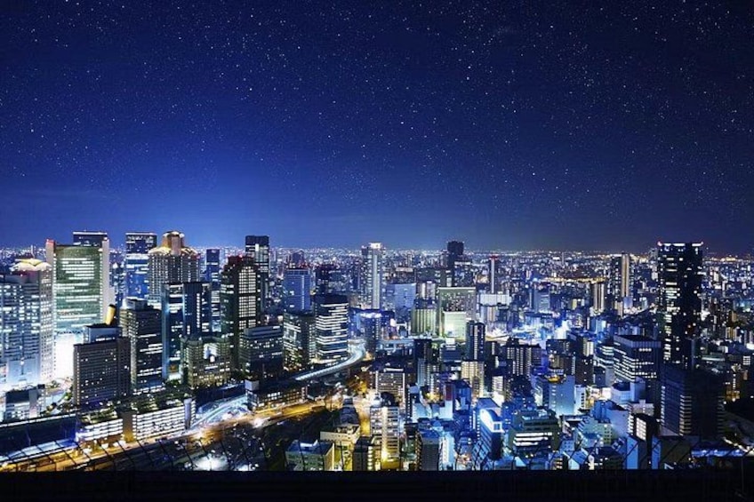 A nighttime cityscape with illuminated buildings and a starry sky. 4