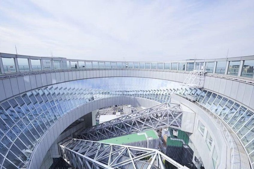 A large, circular stadium with a glass roof and a metal framework. 2
