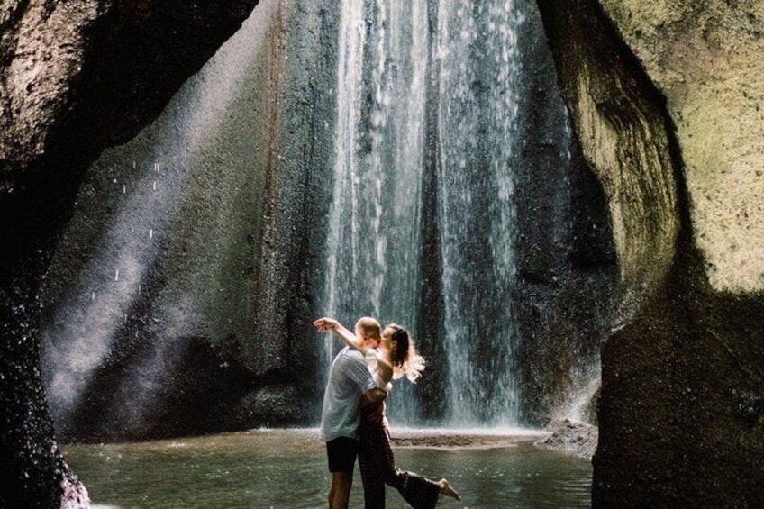 Un couple s’embrasse devant une cascade. 2