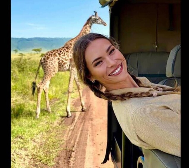 A vehicle with a giraffe in the background. 1