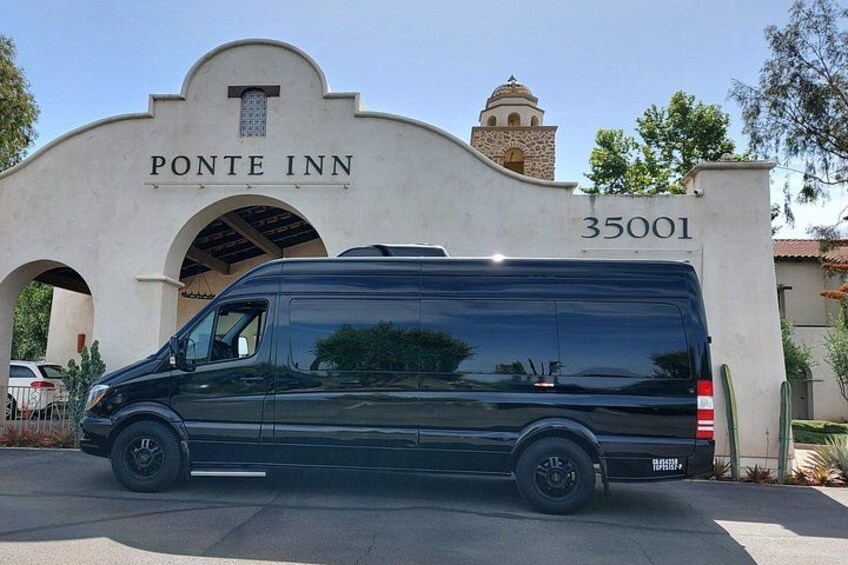A black van parked in front of a building with a sign that reads 'PONTE INN' and the number '35001'. 3