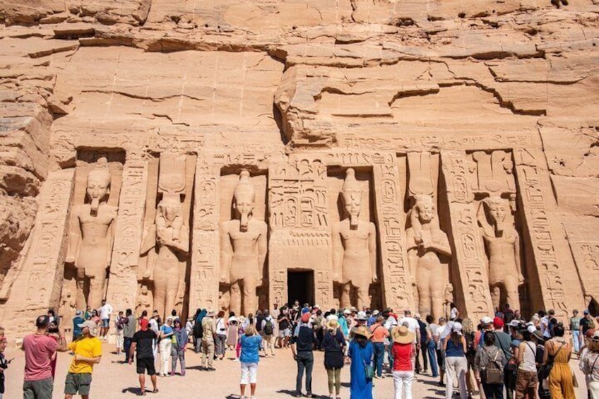 A large rock face with ancient Egyptian statues and hieroglyphics. 2
