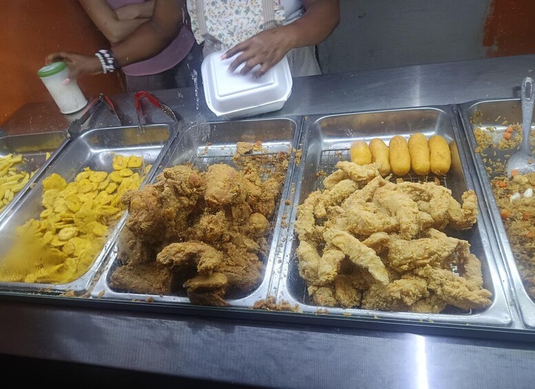 A buffet with various fried foods including corn dogs and fried chicken. 5