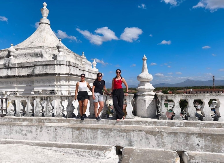 A historical building with a dome and spires, a stone balustrade, and a clear blue sky. 1