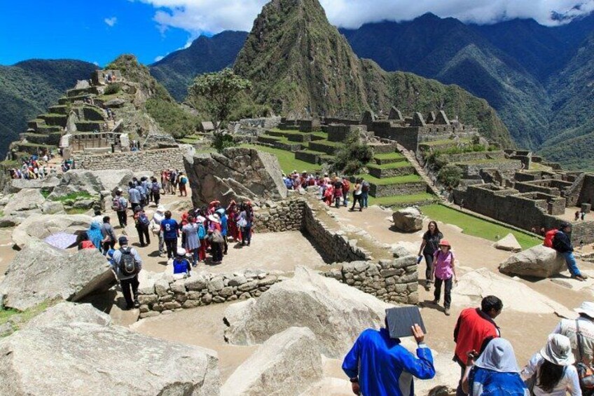 The ruins of Machu Picchu with tourists exploring the site. 4