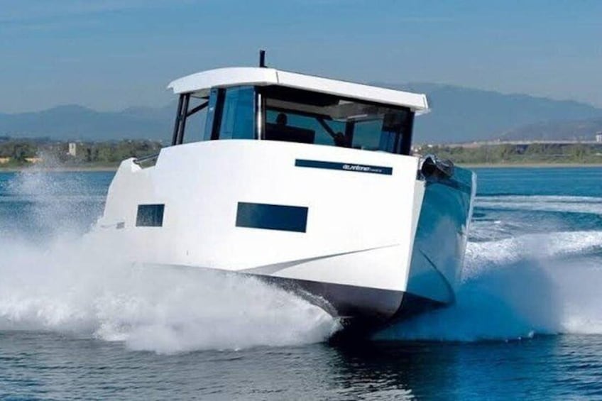 Una barca bianca che scivola veloce sull'acqua, con un paesaggio montuoso sullo sfondo. 5