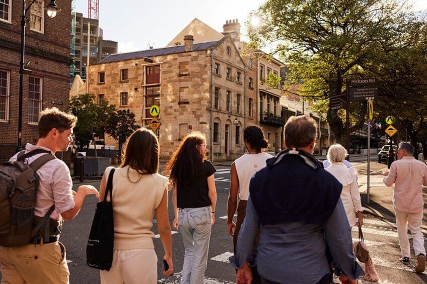 Un grupo de personas caminando por una calle con edificios históricos al fondo. 3