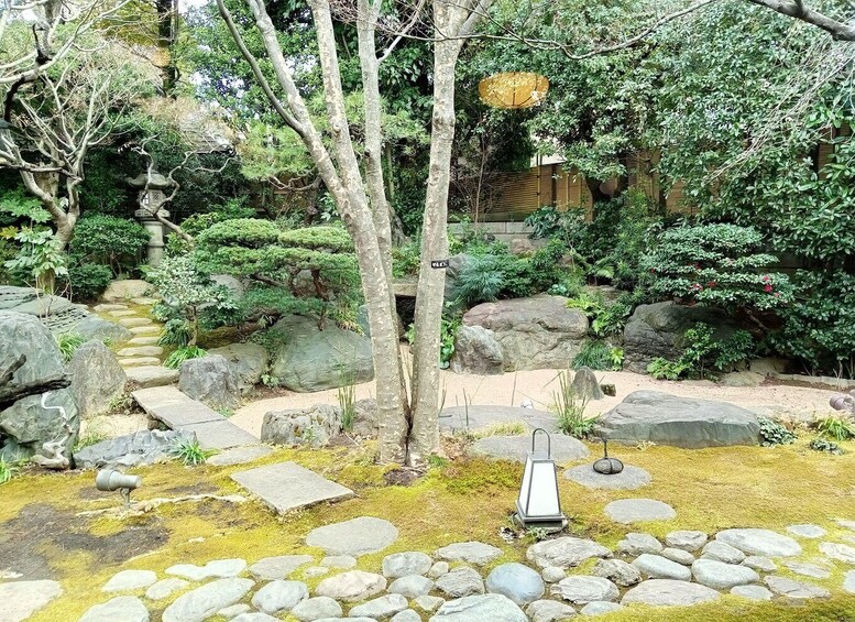 A traditional Japanese garden with rock formations, moss, and a lantern. 4