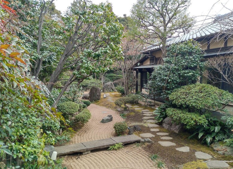 A traditional Japanese garden with a stone path, stepping stones, and various plants. 5