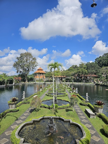 A serene garden with a central fountain, surrounded by neatly arranged flower beds and a calm pond. 2