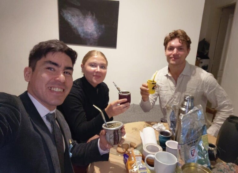 Three people at a table with drinks and a telescope. 2