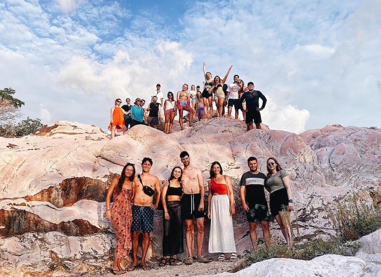 A group of people standing on a rocky outcrop with a clear sky above. 1