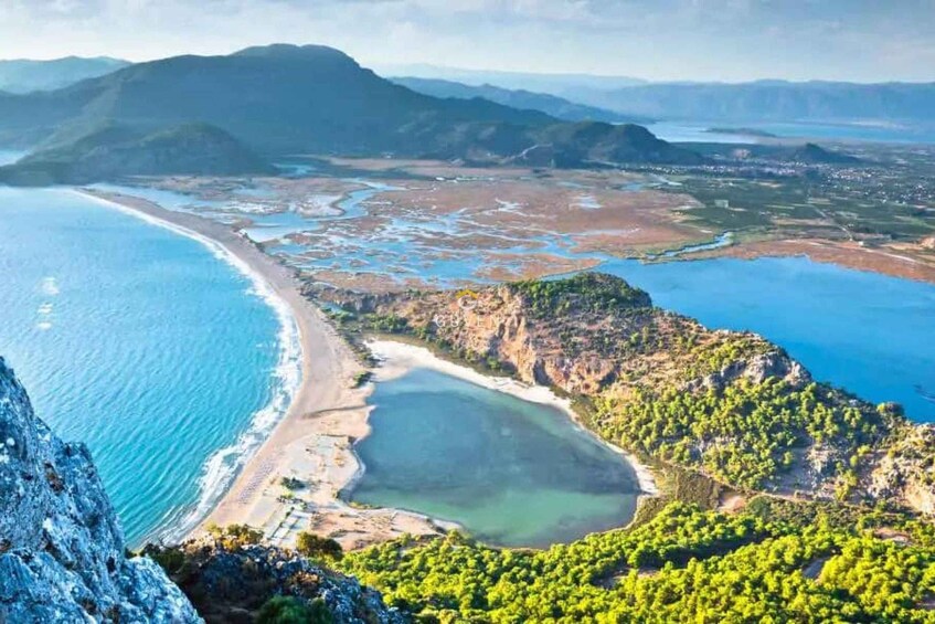 A coastal landscape with a beach, a bay, and surrounding hills. 2
