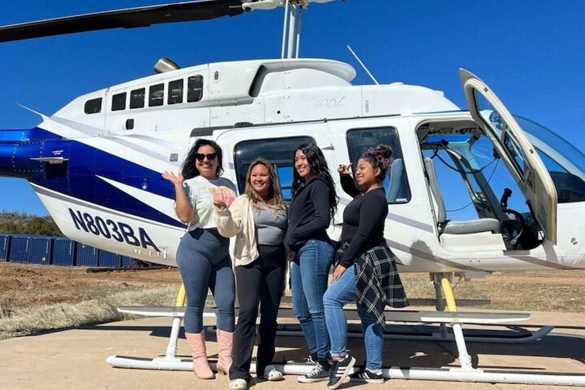A group of people standing in front of a helicopter with the registration N803BA. 5