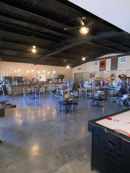 An indoor dining area with tables and chairs, a bar, and a pool table. 4