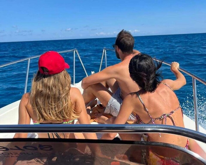 Three people on a boat with the ocean in the background. 1