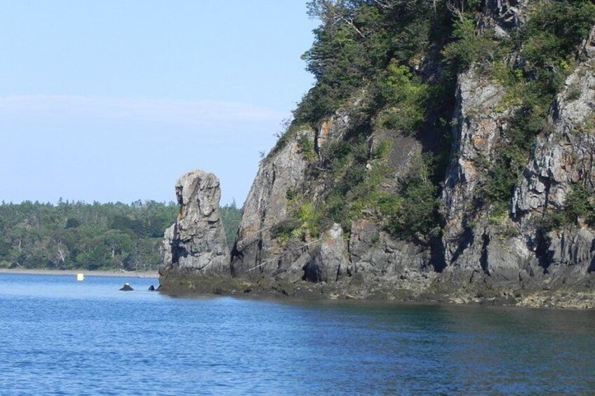 A rocky coastline with a prominent rock formation and calm water. 2