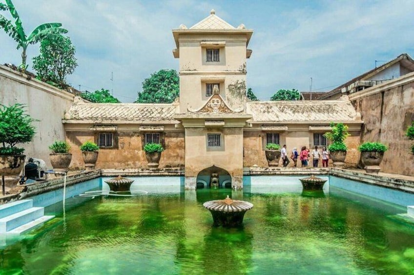 A historic building with a central courtyard, a fountain, and a group of people. 1