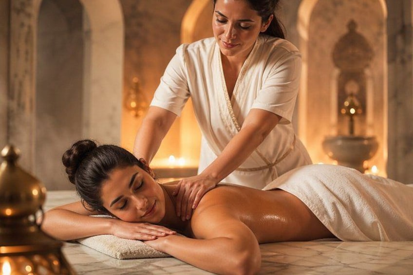 A person receiving a massage in a spa-like setting with stone architecture and candles. 4