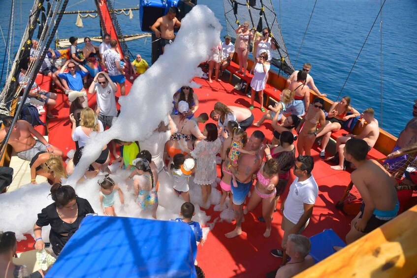 A group of people on a boat with a red deck, surrounded by water. 1