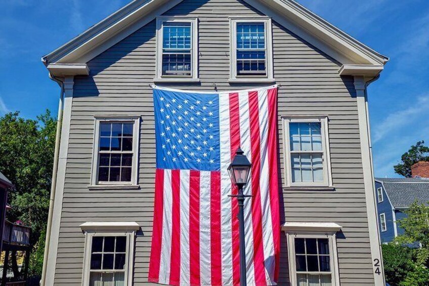 A house with a large American flag and a street lamp. 1
