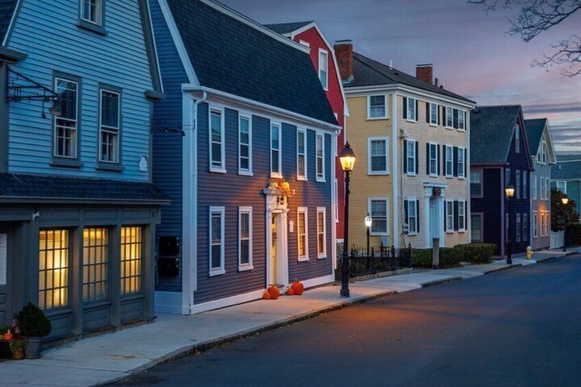 A row of colorful houses with lit windows and a street lamp. 3