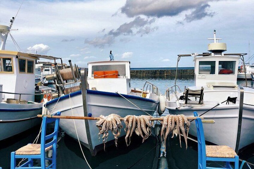 A marina with several boats docked, ropes tied to a central structure, and a person standing on the dock. 2