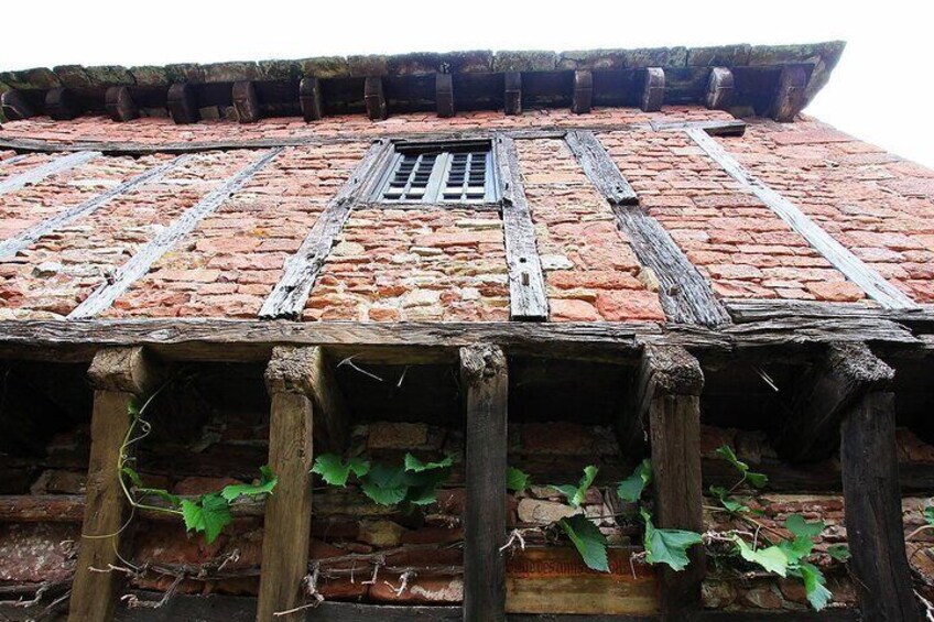 A weathered brick roof with wooden beams and a central drainpipe. 4
