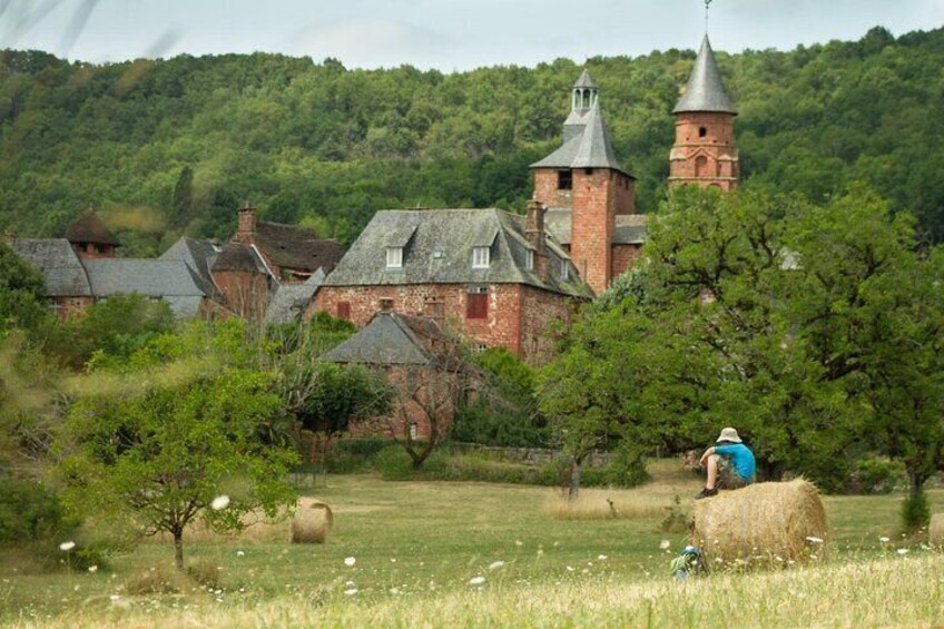 A rural landscape with a church, hay bales, and a person in a field. 2