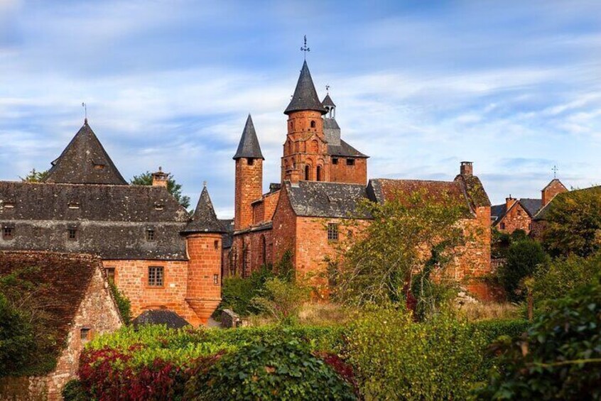 A historic stone building with multiple towers and a prominent bell tower. 1