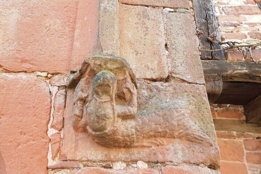 A stone carving of a face on a brick wall. 3