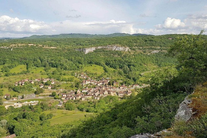 A village nestled in a valley surrounded by lush greenery and hills. 3