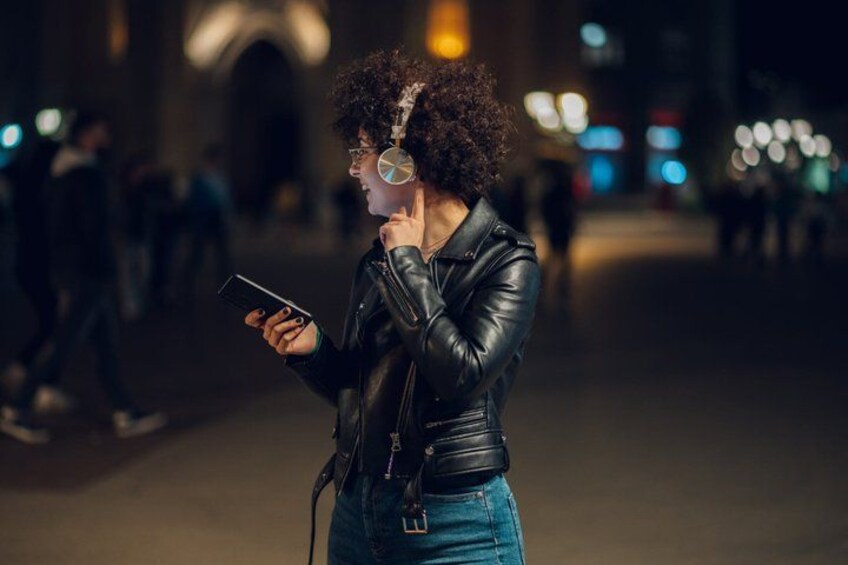 Una persona con chaqueta de cuero y vaqueros sosteniendo un teléfono inteligente. 3