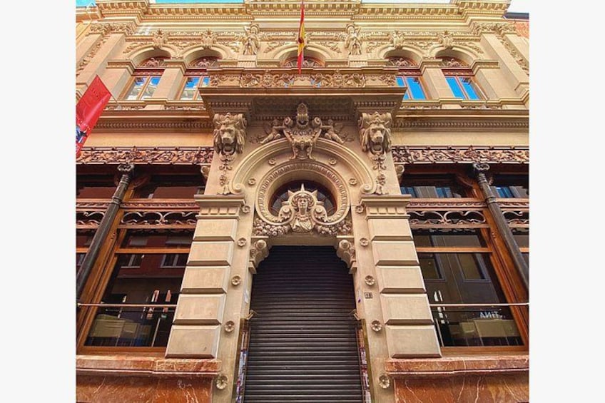 A building facade with ornate architectural details, including a central archway and decorative lion sculptures. 2