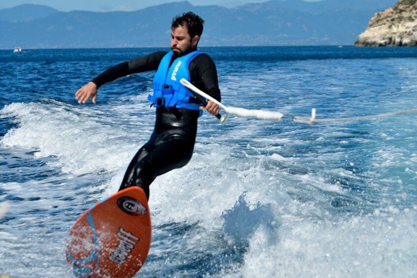 En person som åker wakeboard på ett vattendrag med berg i bakgrunden. 3
