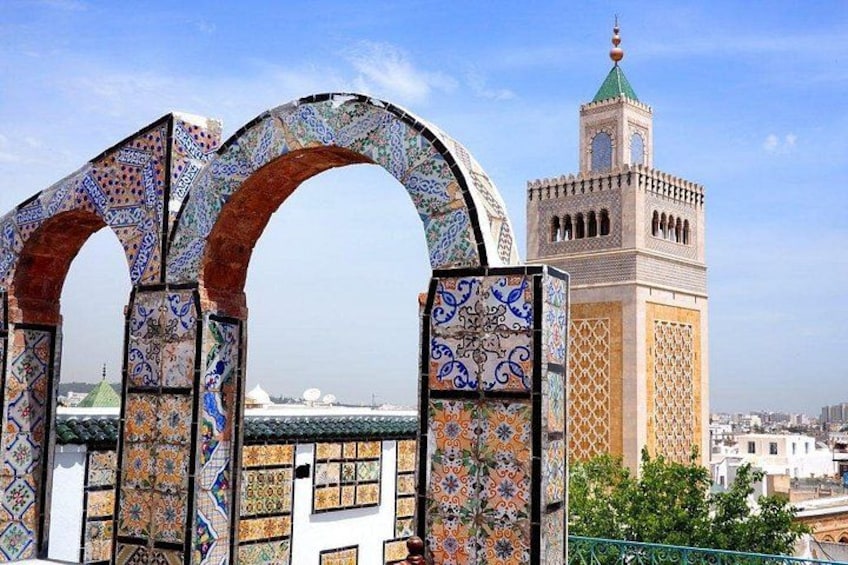 A mosque with a minaret and a decorative archway. 2