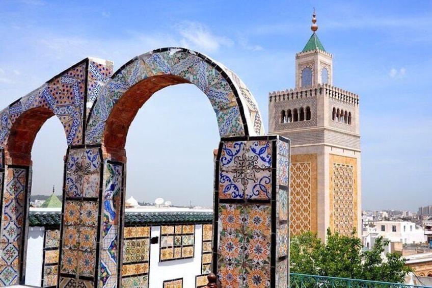 Eine Moschee mit einem Minarett und einem verzierten Torbogen. 2